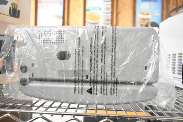 EcoPunch Electric 2-3-Hole Adjustable Punch, new in packaging, plastic wrap with warning text, grey finish, adjustable knobs.