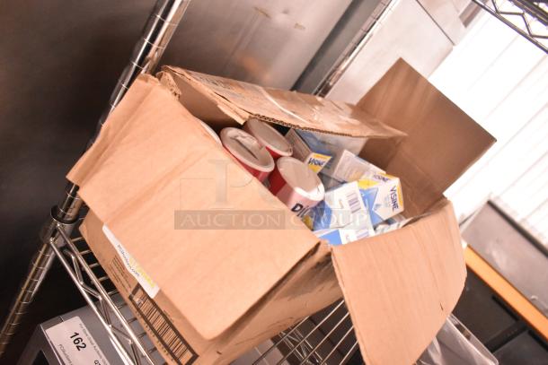 Open box with Visine Dry Eye Relief, Pick Me Up Pure Sugar, and First Aid Eye Care Treatment. Items appear new, packed in a cardboard box on a shelf.