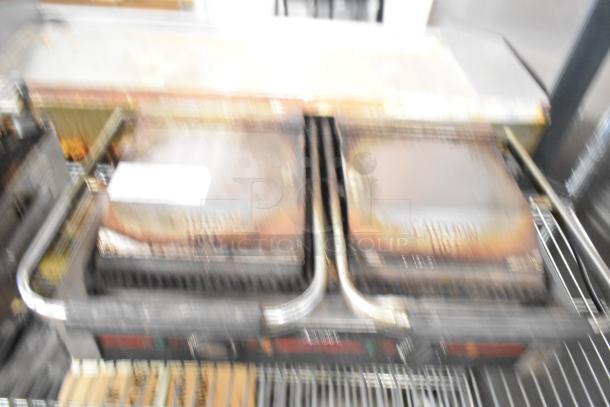 Adcraft SG-813 Countertop Double Panini Press, visible wear, 120 volts, 1 phase. "Caution Hot" label on press surface.