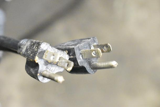 Close-up of an electrical plug with visible wear, connected to the Adcraft SG-813 Panini Press, 120V, 1 Phase.