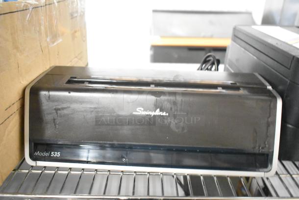Swingline 535 electric 3-hole punch in silver-platinum, holds 28 sheets, creates 9/32" holes. Slight wear visible.