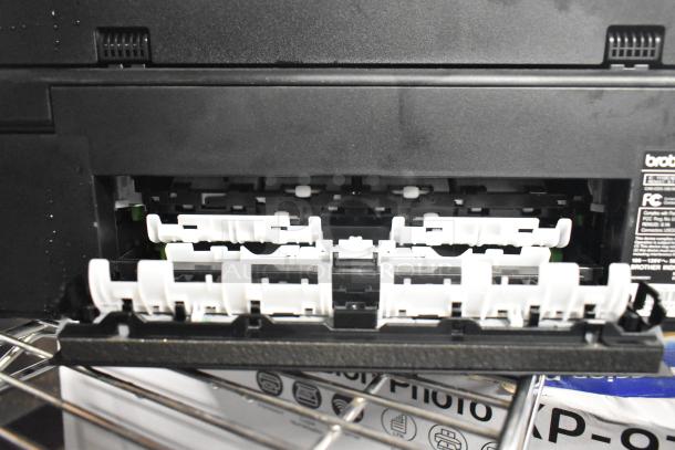 Brother MFC-J1170DW printer with open paper tray, showing internal rollers. Brand and model label visible.