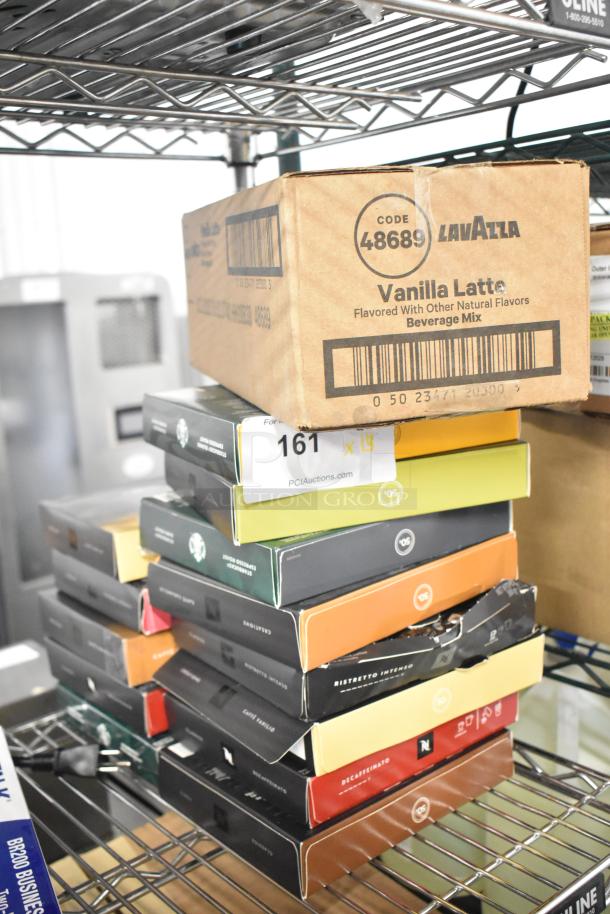 Boxes of LavAzza Vanilla Latte drink mix and various Starbucks coffee roasts stacked on a metal shelf. Auction lot label visible.