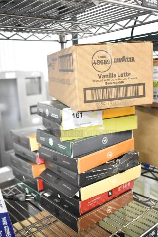Boxes of LavAzza Vanilla Latte drink mix and various Starbucks coffee roasts stacked on a metal shelf. Auction lot label visible.