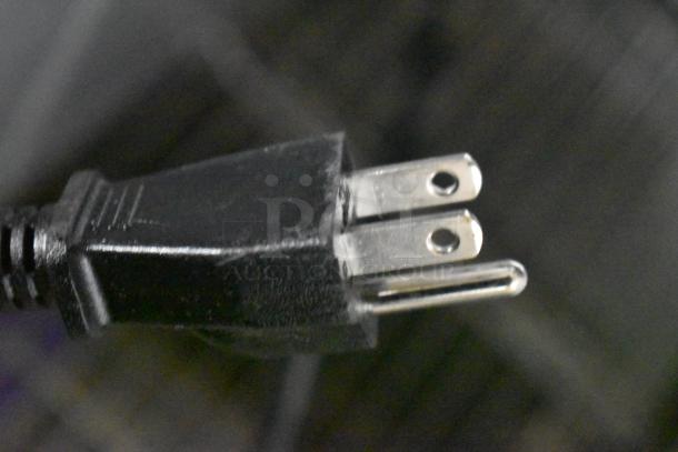 Close-up of a power plug showing a three-prong, black electrical cord, likely part of the Avanti MT116V4M Microwave.