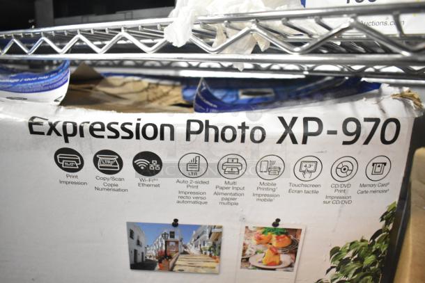 Epson Expression Photo XP-970 printer box showing features: Wi-Fi, auto 2-sided print, touchscreen, CD/DVD print, memory card slots.