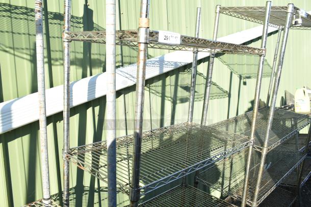 Chrome finish 4-tier wire shelving unit with visible wear. Includes label with quantity details. Buyer must dismantle.