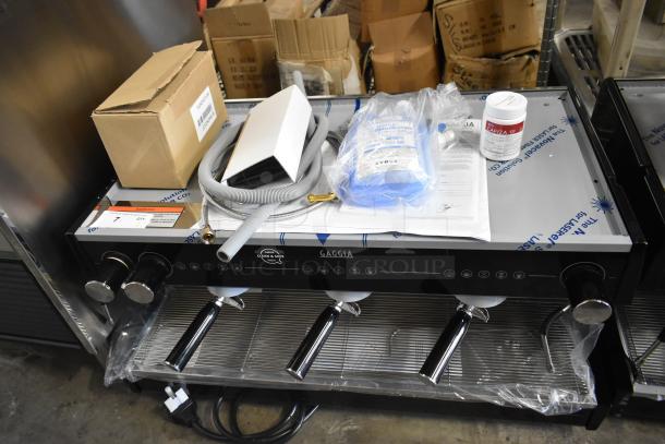 Brand new Gaggia MGV293NPU Vetro Black 3 group automatic espresso machine, 220/230V, with visible accessories and parts.