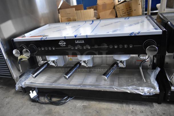 Brand new Gaggia MGV293NPU Vetro Black 3 Group Automatic Espresso Machine, 220/230V, visible labels; slight scratches.