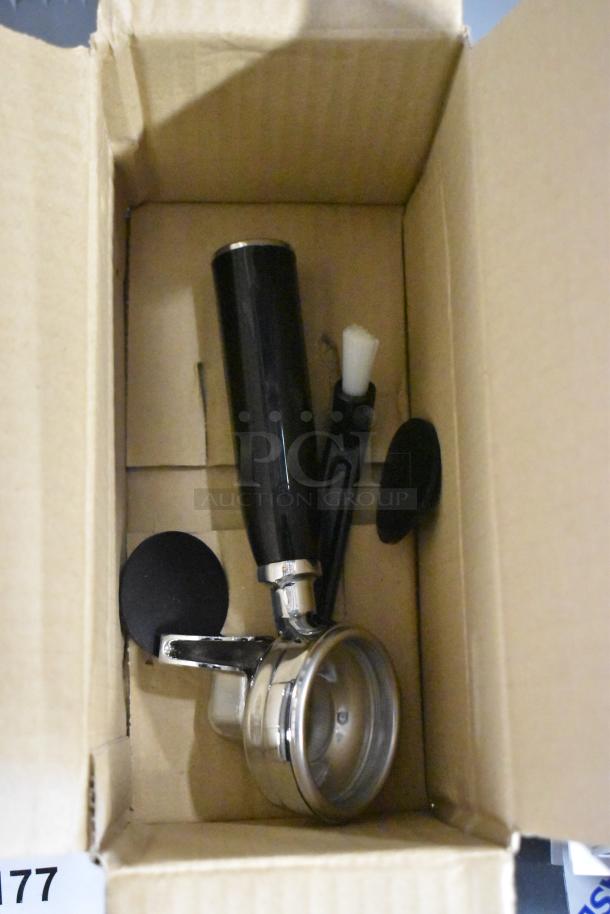 Boxed accessories for Gaggia MGV293NPU espresso machine, including a portafilter and cleaning brush. Brand new condition.