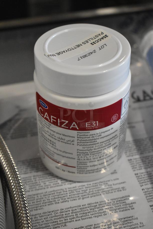 Alt text: Cafiza E31 Espresso Machine Cleaning Tablets bottle with multilingual instructions and LOT 2423817 label on cap.