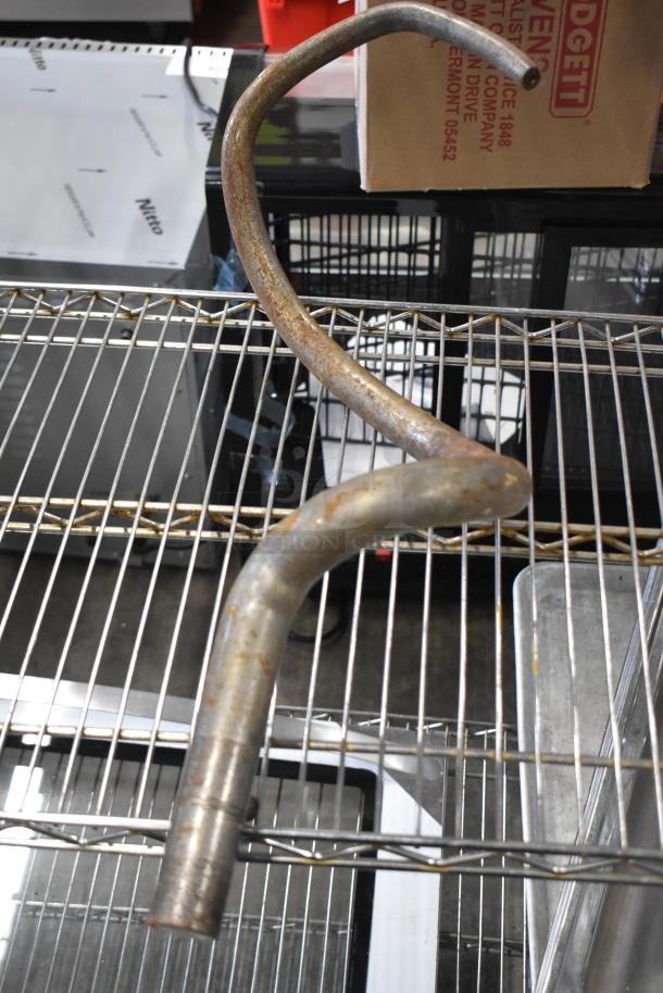 Four dough hook attachments for Hobart mixer, slightly rusted metal, suitable for heavy-duty mixing.