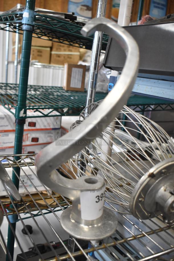 Dough hook and whisk attachments for Hobart mixer, metal finish, on a shelf with price tag.