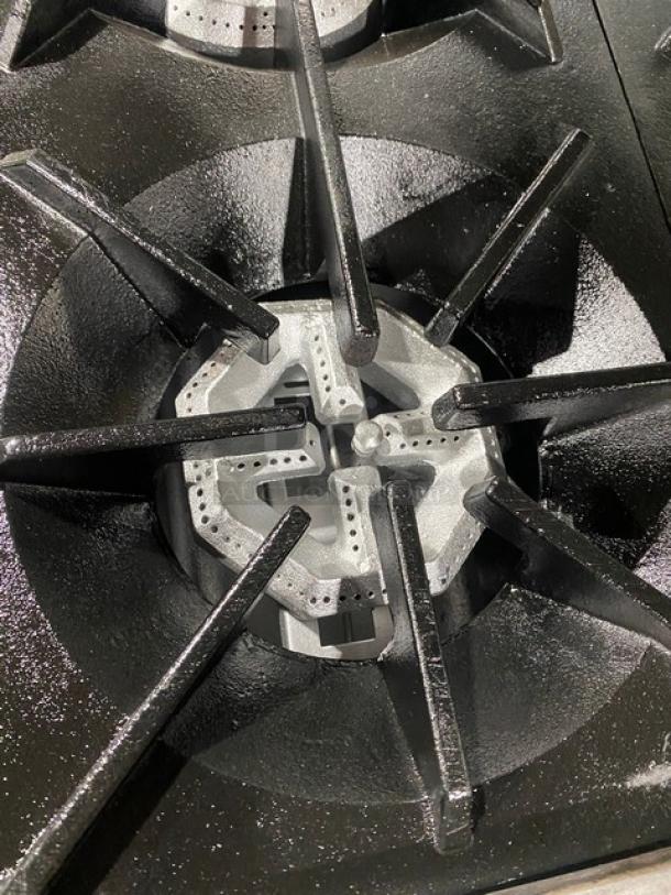 Tri-Star commercial stainless steel gas burner detail, part of a 6-burner range/oven combo. Features heavy-duty cast iron grates.