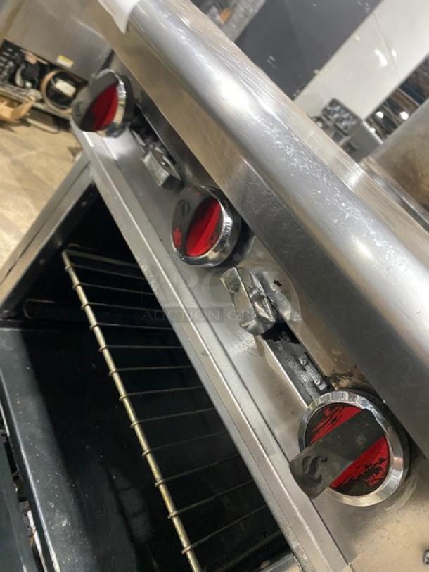 American Range stainless steel 4-burner range/oven combo with backsplash, overhead salamander shelf, and wired oven rack.