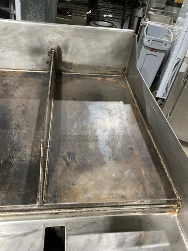 WoodStone stainless steel natural gas countertop plancha griddle, model WS-PL-4836-4-CT00NG, with back and side splash, split top, and caster wheels.