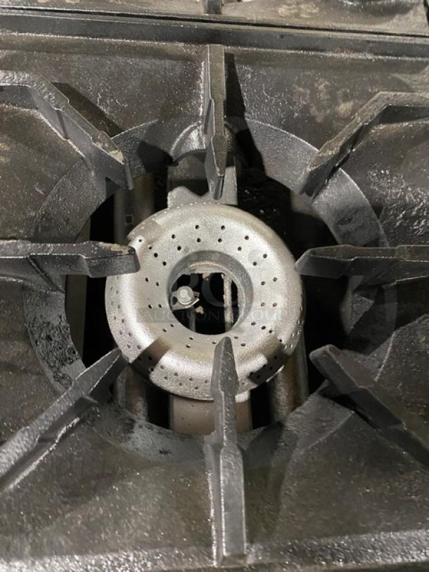 American Range commercial stainless steel gas-powered countertop 4-burner range, close-up of burner, well-maintained.