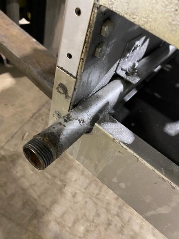 American Range commercial gas-powered 4-burner countertop range. Stainless steel frame with visible wear. Ideal for restaurants.