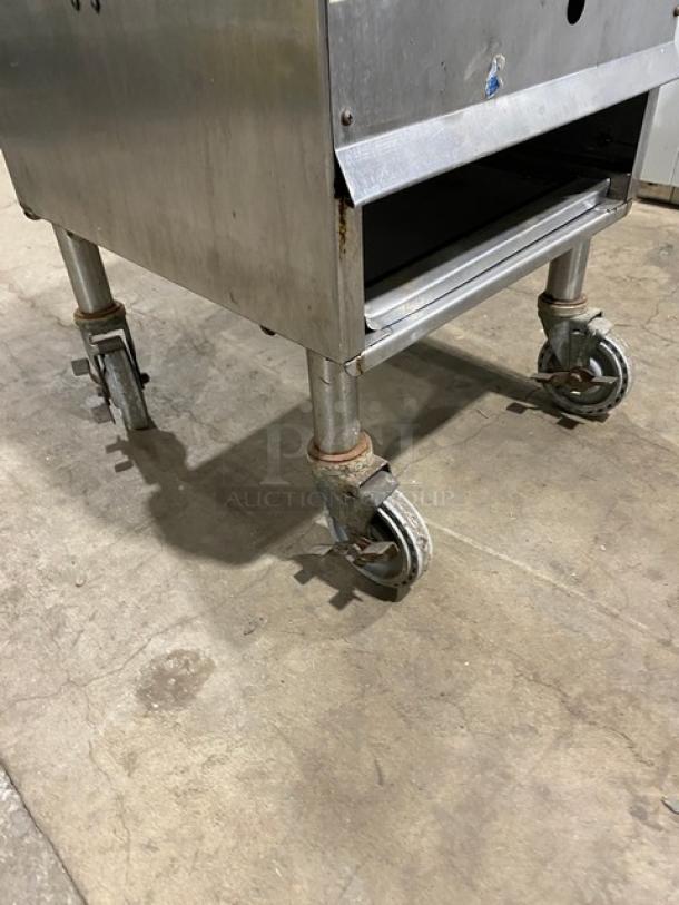 U.S. Range single burner stock pot range on casters, natural gas powered, stainless steel, moderate wear, rust on wheels.