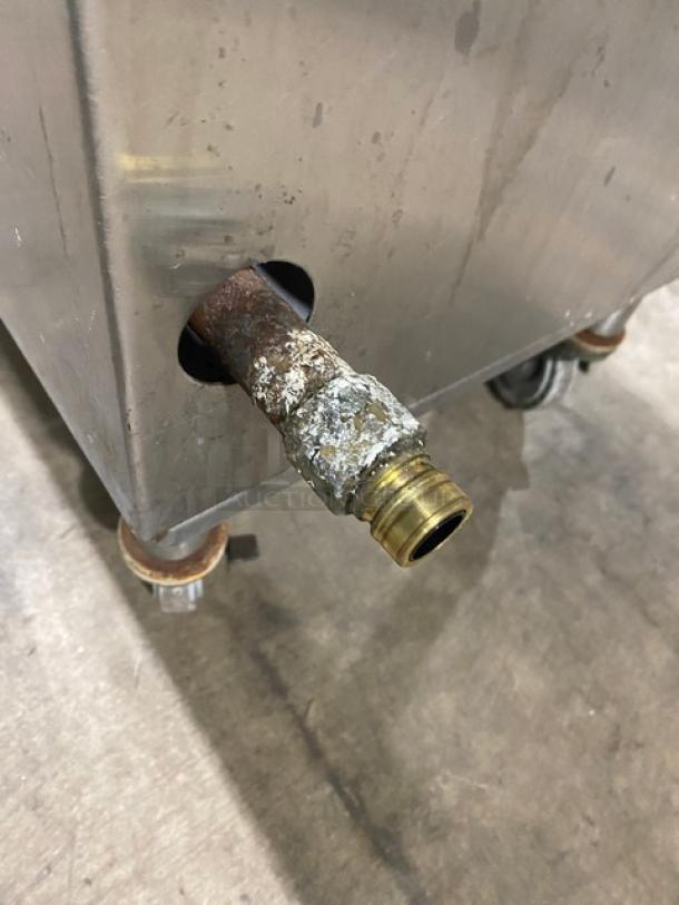 U.S. Range single burner stock pot range, natural gas powered, on casters, shows wear and rust on fittings.