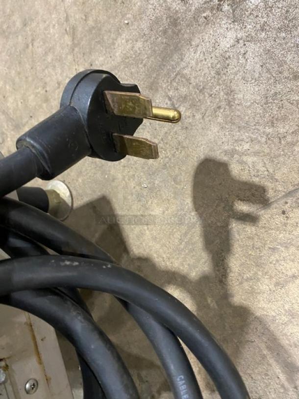 Close-up of a black electric power cord with a three-prong plug, part of the TurboChef NGO model rapid cook oven.