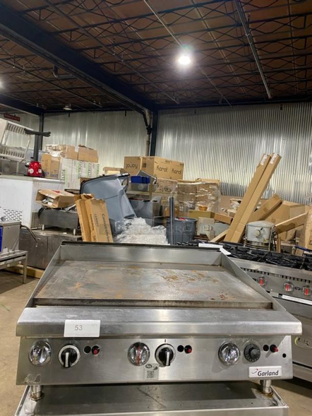 Garland GTGG36-GT36M stainless steel gas countertop griddle on legs. Features dials, used condition, serial number visible.