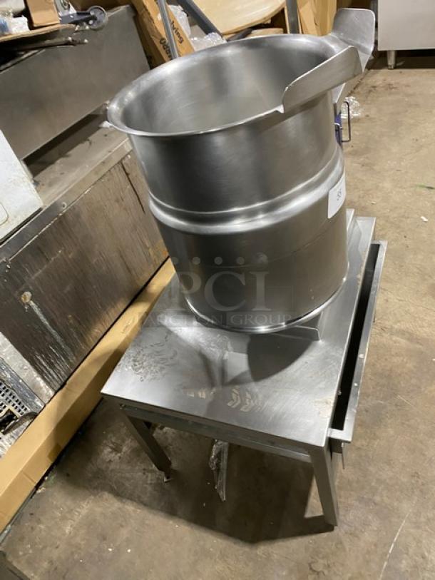 Cleveland Range stainless steel steam jacketed tilting kettle with swing spout faucet, single drawer equipment stand, on legs.