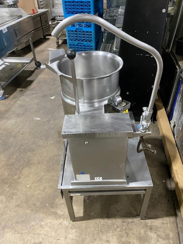 Cleveland Range stainless steel steam jacketed tilting kettle with swing spout faucet, single drawer stand, on legs.
