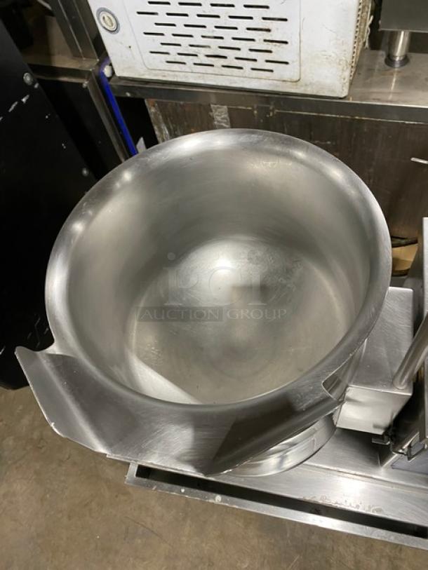 Cleveland Range stainless steel steam jacketed tilting kettle with swing spout faucet, single drawer equipment stand, on legs, commercial use.