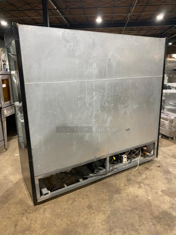 Sanye commercial black multi-tier refrigerated open grab-n-go merchandiser display case, back view, warehouse setting.