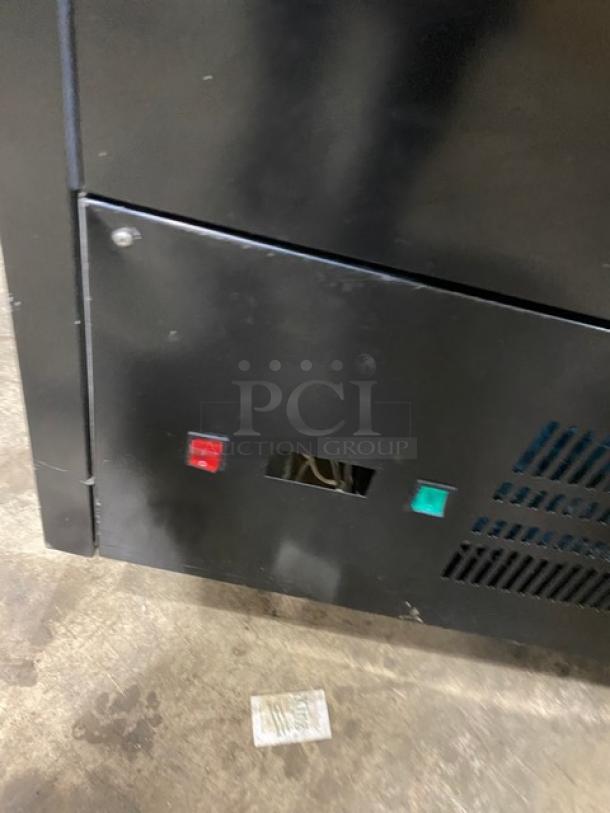 Sanye black multi-tier refrigerated merchandiser display case, commercial-grade, condition shows minor wear, features control panel.