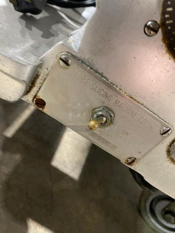 Globe model 660 electric deli meat slicer, serial 674425. Metal label indicates "Globe Slicing Machine Co." On legs, functional condition.