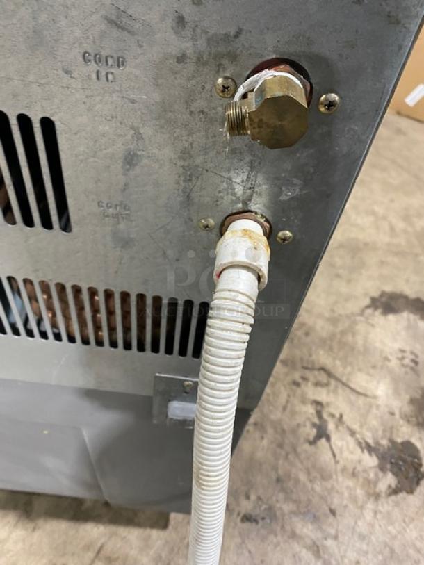 Hoshizaki KM250BWE ice machine rear view showing connections and metal casing. Model: KM-250BWE, SN: J02136D.