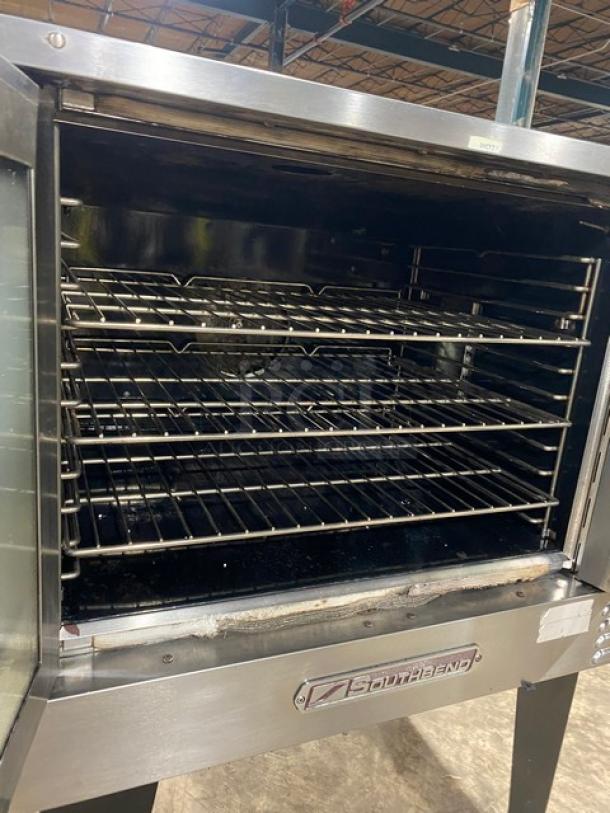 Southbend commercial stainless steel gas convection oven with thermostatic control, wired oven rack, on legs, open door.
