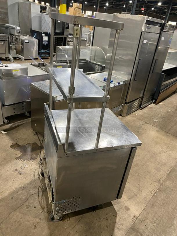 True TWT-27 stainless steel worktop refrigerator with single door, double overhead shelf, and backsplash. On casters.