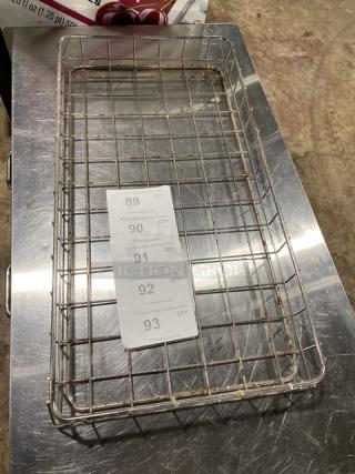 Commercial chrome-plated full-size bagel/pastry wired rack, used condition, visible wire grid design, auction labels displayed.