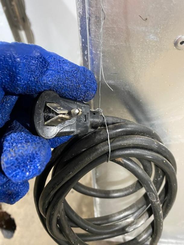 Power cord of a Glastender MFV24GNL mug chiller, 2018 model, 120V, single phase, shown with a hand in a blue glove holding the plug.