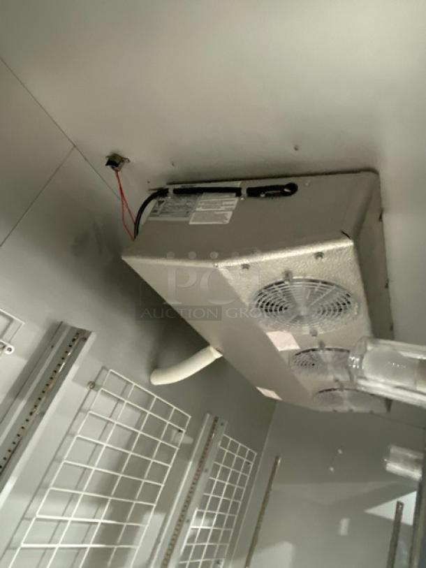 Three-door commercial refrigerator, white finish, poly-coated wire racks, solid construction, internal view with cooling elements.