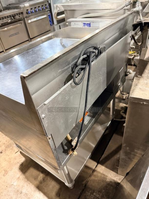 MagiKitch'n commercial flat griddle with mirror shine, stainless steel stand, thermostatic controls, natural gas-powered.