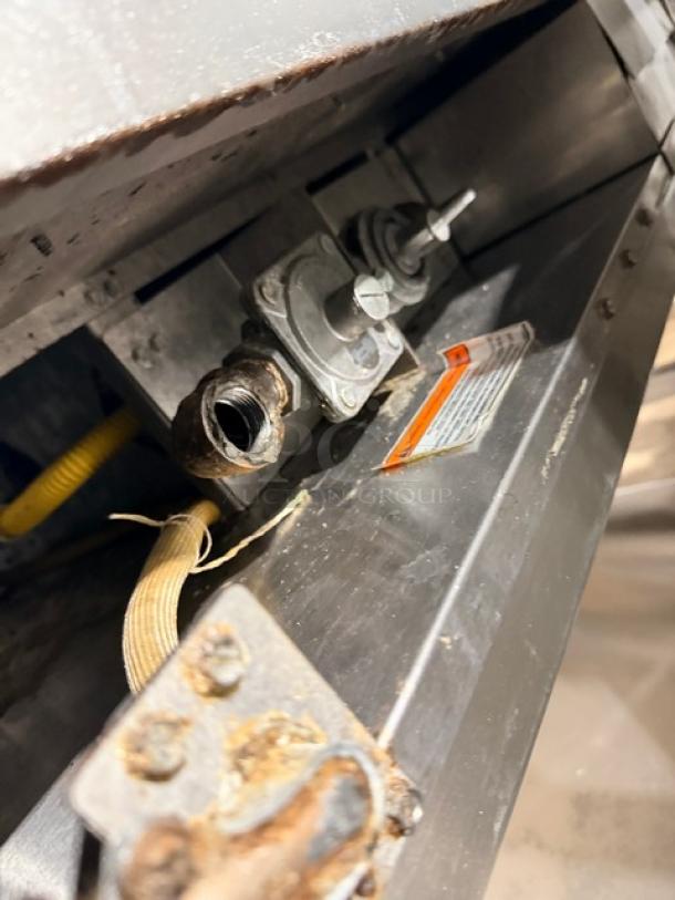 MagiKitch'n natural gas flat griddle, thermostat controlled, on stainless steel stand; visible gas connections and label.