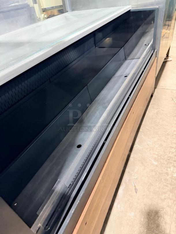 Structural Concepts SBZ6652DR black open refrigerated merchandiser with top glass showcase, rear sliding doors, on legs.