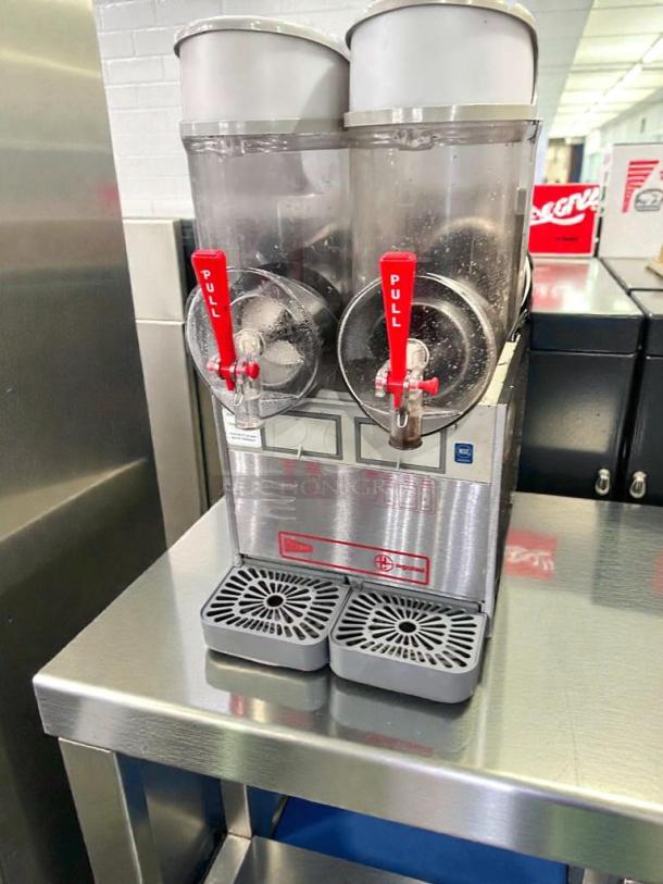 Ugolini NHT2 double bowl slush machine, superior condition, NSF & UL listed, features clear bowls, red pull levers, stainless finish.