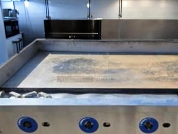 Commercial griddle by Globe Food Equipment, Model GG48G. Stainless steel, blue knobs, preheated surface, fully operational.