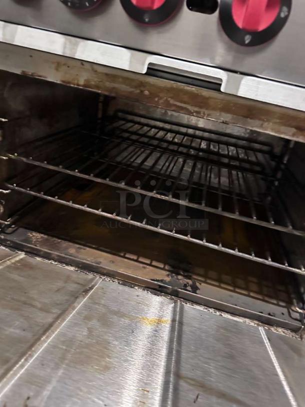 Montague 6-burner commercial gas range oven interior, NSF listed, natural gas, fully operational, visible shelves, used condition.