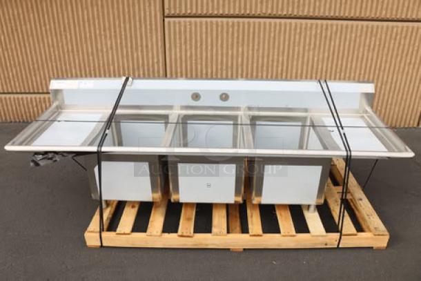 Regency 94" stainless steel sink, three compartments, two drainboards, 16 gauge. Minor scratches, scuffs, dents visible. Model 600S31824218.