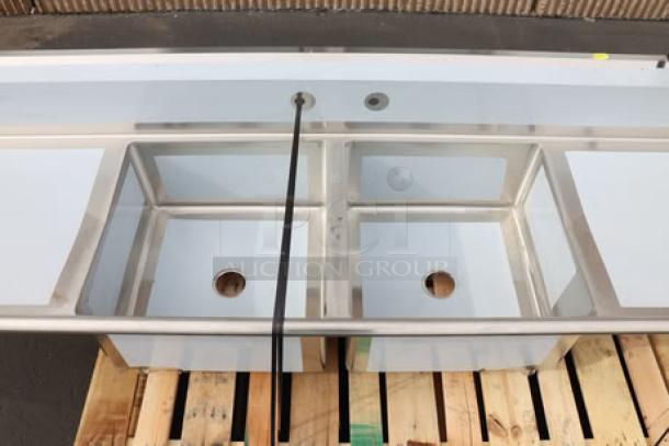 Regency S2C232312-24L&R two-compartment stainless steel sink with 2 drainboards, 96" length, new with minor scuffs.