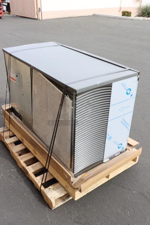Brand new Manitowoc IYT1500A ice machine on a pallet, exterior scratched and dented, air-cooled, 1660 lb capacity.