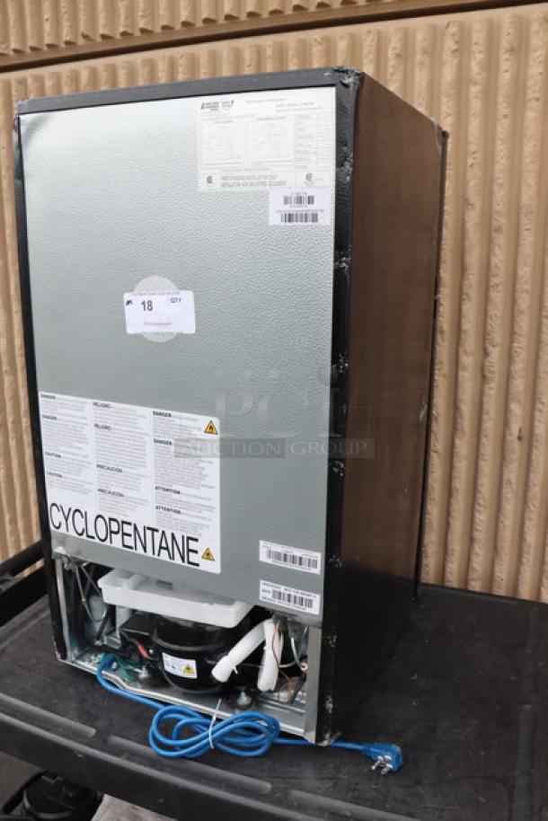 Brand new Danby 3.1MF7-7B1 MicroFridge, 3.1 cu. ft., black, two-door refrigerator/freezer with microwave. Tags indicate model and safety info.