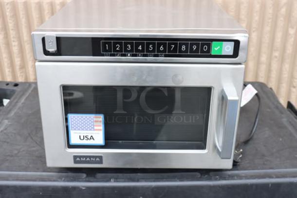 Amana HDC12A2 commercial microwave, stainless steel, push button controls, 120V, 1200W. Minor dent top right, door slightly off.