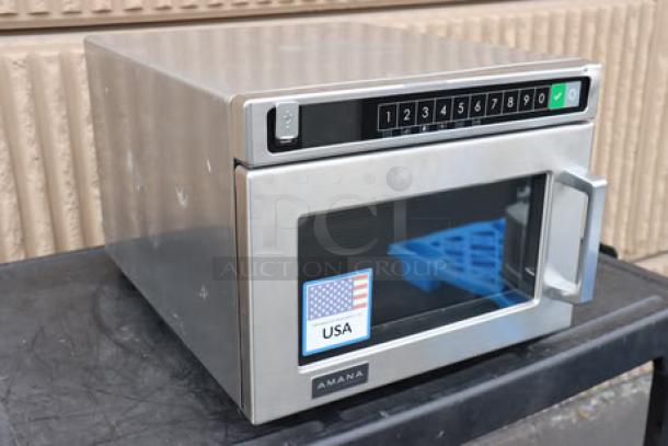 Brand new Amana HDC12A2 commercial microwave, 120V, 1200W, stainless steel, minor dent, door slightly misaligned. USA label visible.